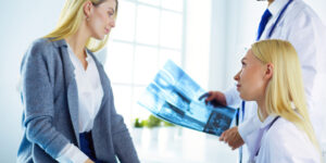 Doctor holding Xrays and consulting with female patient